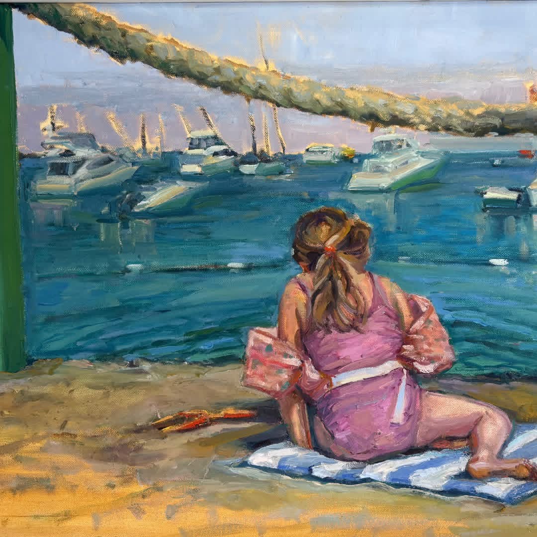 Plein air painting of a woman resting on the beach and watching the boats in Avalon harbor